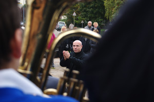 Director Pierre Boesplug through a Godalming Band horn