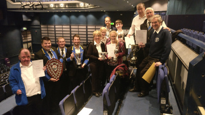 Celebrating in the theatre with trophies from the B section win